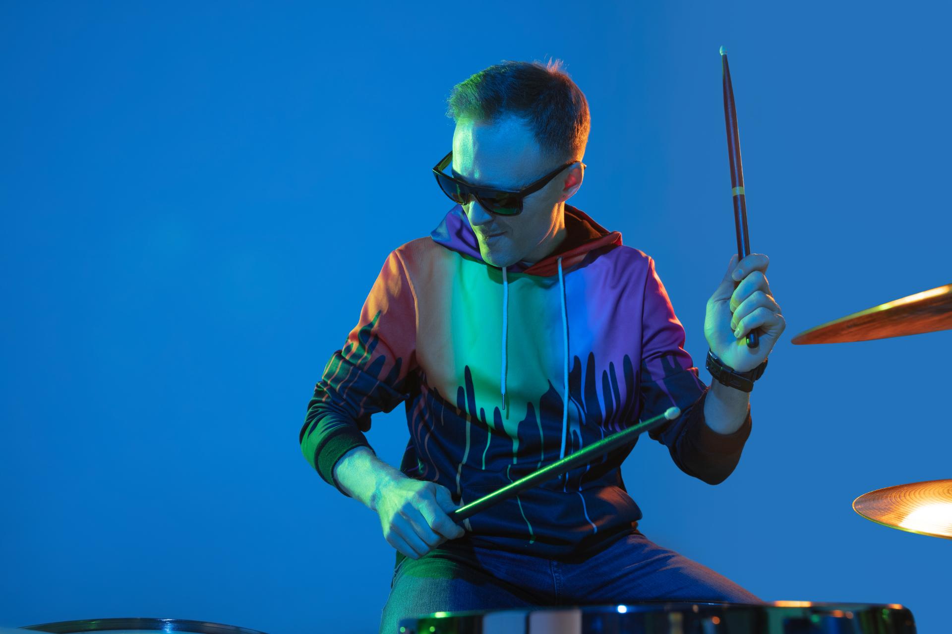 energy-young-inspired-expressive-musician-drummer-performing-gradient-colored-wall-neon-light-...jpg
