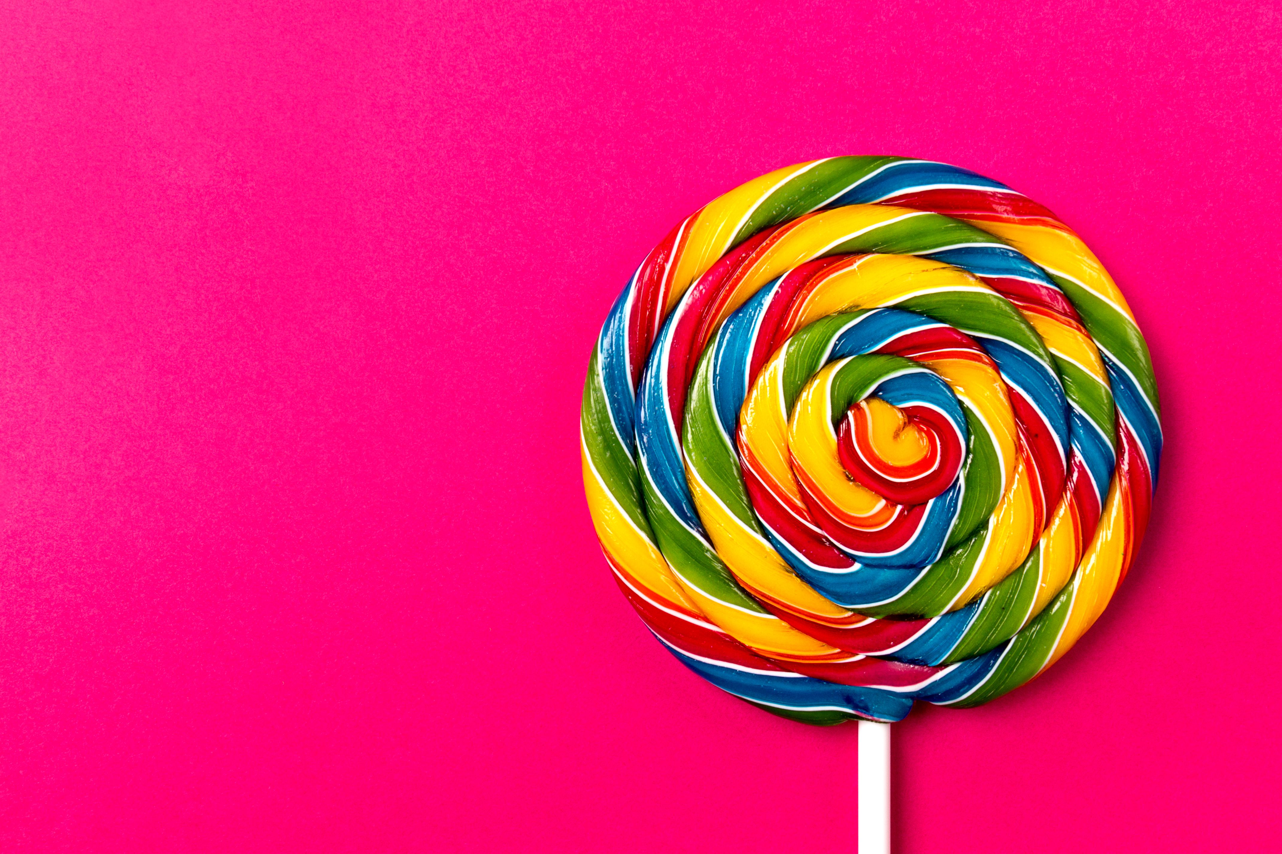 tasty-appetizing-party-accessory-sweet-swirl-candy-lollypop-pink-background-top-view (1).jpg